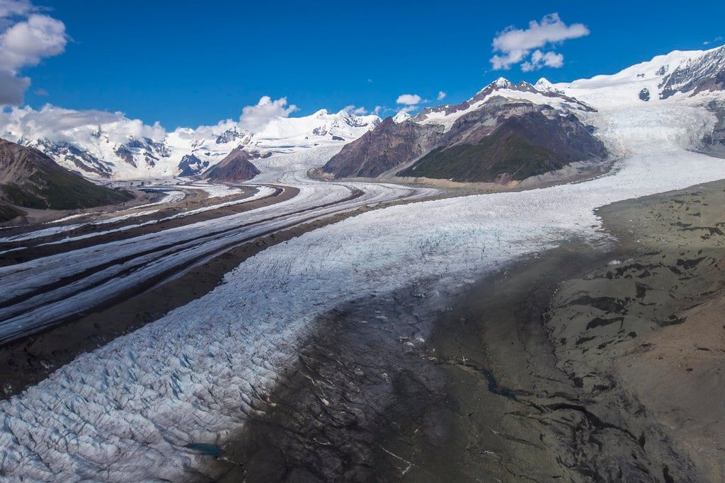 Aerial view of the vast Kennicott Glacier and its dark medial moraines winding through the mountains of Alaska.